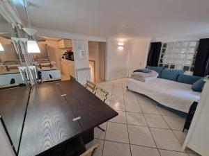 a living room with a table and a bed in it at Le Cosy - Hyper Center 2 room apartment in Nice