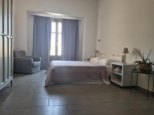 una camera con un letto e una sedia e una finestra di Aviola Mykonos a Ftelia