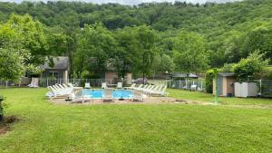 un patio con una piscina con sillas y una valla en Village 17 gites, Piscine, Restaurant , 2 gites avec SPA, 3km de Conques, en Conques