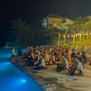 tłum ludzi siedzących w nocy przy basenie w obiekcie BAKHAN VIEWEST GLAMPING w mieście Mai Châu