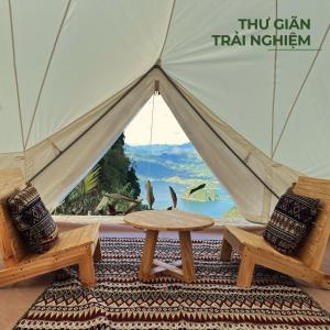 una tienda con 2 sillas y una mesa frente a ella en BAKHAN VIEWEST GLAMPING en Mai Chau