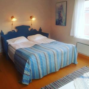 a bedroom with a bed with a blue and white blanket at Lövånger Kyrkstad in Lövånger