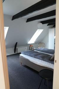 ein Schlafzimmer mit einem Bett in einem Zimmer mit Oberlichtern in der Unterkunft Penthouselejlighed midt i Vejle in Vejle