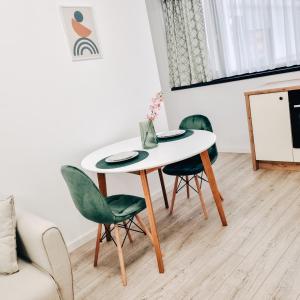 einen Tisch und Stühle im Wohnzimmer in der Unterkunft Bijou Aparthotel in Galaţi