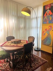 een eetkamer met een tafel en stoelen en een lamp bij Casa in Prato in Padua
