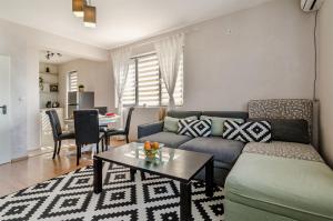 ein Wohnzimmer mit einem Sofa und einem Tisch in der Unterkunft Апартаменти Ивайло / Ivaylo apartments in Burgas City