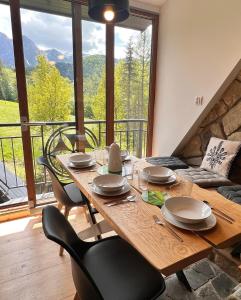 a dining room table with chairs and a large window at Villa Tatrydom in Zakopane