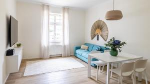 een woonkamer met een blauwe bank en een tafel bij Italyescapes Emma 22 NEW 2023 in Merano