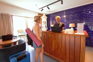 a man and a woman standing at a cash register at WOT Costa da Caparica in Costa da Caparica