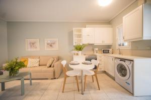 eine Küche und ein Wohnzimmer mit einem Sofa und einem Tisch in der Unterkunft Barbati Bay Elegant Beach Apartments by Hotelius in Barbati