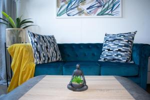 a living room with a blue couch and a table at 101 Bridgewater Apartment in Cape Town