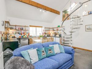 a living room with a blue couch with pillows at Shundraw Cottage in Keswick