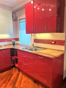 una cucina con armadi rossi e lavandino di Casa in Prato a Padova