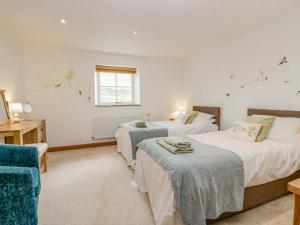 a bedroom with two beds and a window at Shundraw Cottage in Keswick