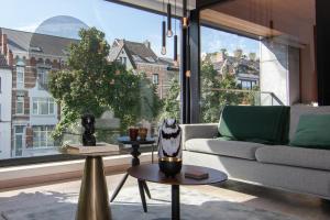 a living room with a couch and a large window at Boulevard Botanie city apartment with parking in Hasselt