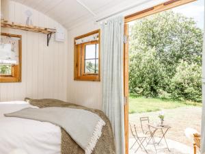 a bedroom with a bed and a window at Coombe Valley Shepherd's Hut in Shaldon