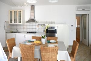 a kitchen with a table and chairs and a kitchen with white cabinets at Conero Casa - Marcelli di Numana in Piazzale Eolie 7 in Marcelli