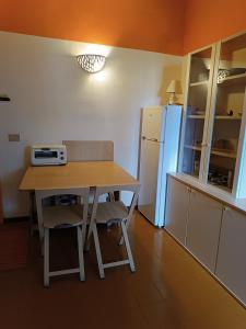 Una pequeña cocina con una mesa y un refrigerador. en Mediterranea, en Cannigione