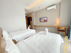 - 2 lits dans une chambre d'hôtel avec des draps blancs dans l'établissement Choe Hotel Banbueng, à Ban Bung