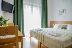 sypialnia z łóżkiem z zielonymi zasłonami i telewizorem w obiekcie Cudne Manowce w Wiśle