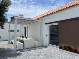 una casa bianca con pergolato e patio di Fazenda do Pomar by Trip2Portugal a Montemor-o-Novo