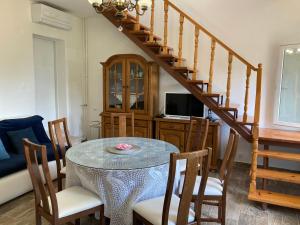 uma sala de jantar com uma mesa com cadeiras e uma escada em Apartment Adria Lovran em Lovran