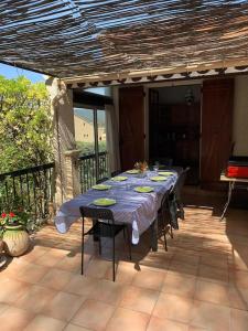 a table on a patio with a blue table cloth at Villa La Louette, 100m centre-village, piscine h-sol, proche mer in Saint-Cyr-sur-Mer