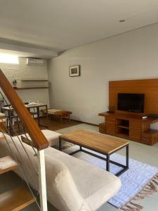 salon z kanapą i telewizorem w obiekcie Balcony Living Apartment w mieście Seminyak