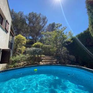 una gran piscina azul junto a una casa en Villa La Louette, 100m centre-village, piscine h-sol, proche mer, en Saint-Cyr-sur-Mer