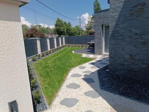 einen Garten mit Gras und Felsen an der Seite eines Hauses in der Unterkunft Villa neuve entre Lac & Montagne in Thonon-les-Bains