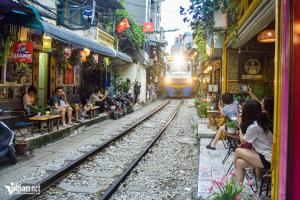 a train is coming down the tracks in a city at MH Hanoi Hotel in Hanoi