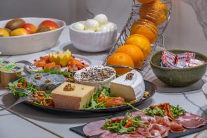 una mesa cubierta con una bandeja de queso y fruta en La Clef des Châteaux en Maslives