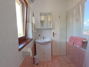 a white bathroom with a sink and a shower at Apartment Adria Lovran in Lovran +11 photos