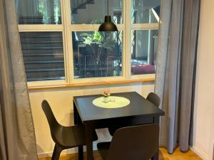 einen Tisch und Stühle in einem Zimmer mit Fenster in der Unterkunft Söderåsen Resort in Ljungbyhed