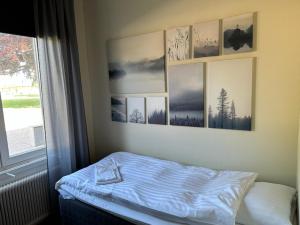 a bed in a room with pictures on the wall at Söderåsen Resort in Ljungbyhed