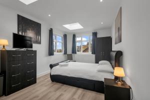sypialnia z łóżkiem i telewizorem w obiekcie Modern Apartment in South West Wandsworth w Londynie