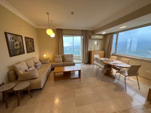 ein Wohnzimmer mit einem Sofa und einem Tisch in der Unterkunft Alanya gold city hotel main building 3 bedroom apartment in Alanya