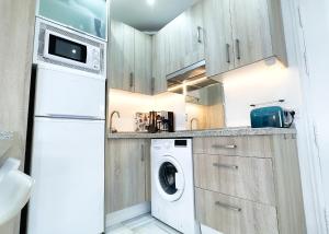 eine Küche mit einem weißen Kühlschrank, einer Waschmaschine und einem Trockner in der Unterkunft Skol 438 Super One-bedroom Apartment with Sea Views in Marbella