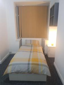 Kunda House Oliver في برمنغهام: غرفة نوم صغيرة مع سرير في غرفة