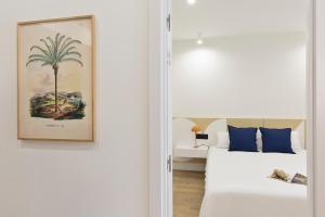 sypialnia z łóżkiem i palmą w obiekcie Diagonal Apartments by Olala Homes w Barcelonie