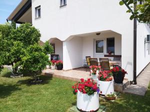 a white house with flowers in the yard at Marijan in Pula