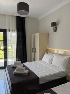 a bedroom with a bed with two towels on it at Otel Beyaz İnci in Palamutbuku