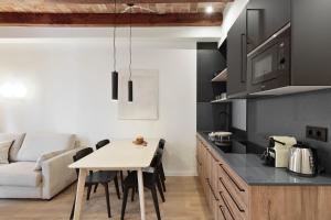 a kitchen and living room with a table and a couch at Olala Diagonal Apartments in Barcelona