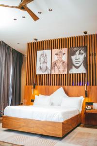 a bedroom with a bed with pictures on the wall at Burundi Palace Boutique Hotel in Bujumbura