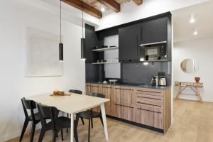 a kitchen with a wooden table and a dining room at Olala Diagonal Apartments in Barcelona