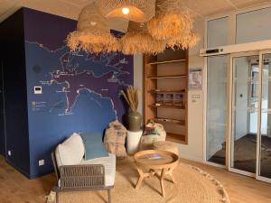 a living room with a blue wall with a map at L'Escale Marine, The Originals Relais in Crozon