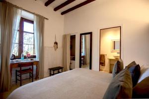 1 dormitorio con cama, escritorio y ventana en Agroturismo Son Boronat, en Calviá