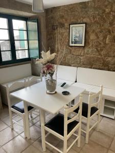 a dining room with a white table and chairs at Casa Dulce in Porto do Son