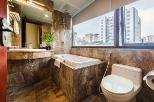 y baño con aseo, lavabo y bañera. en One Hotel, en Hanói