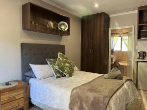 1 dormitorio pequeño con 1 cama y cocina en Panorama Self Catering, en Panorama